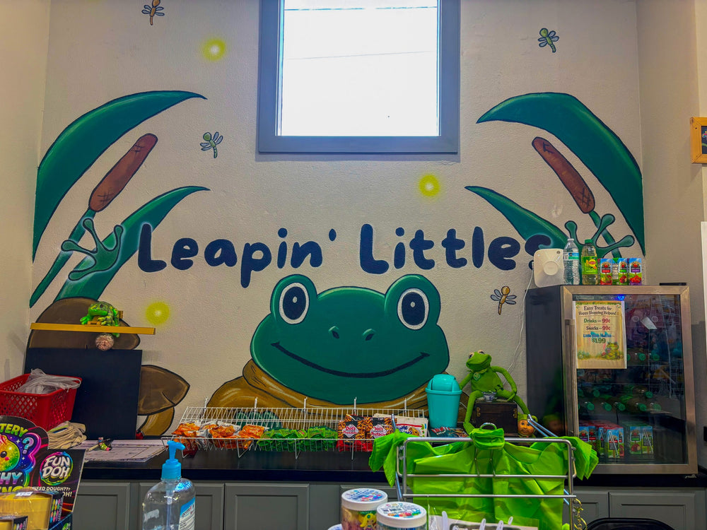 Inside Leapin' Littles — hand-painted frog mural above the checkout counter